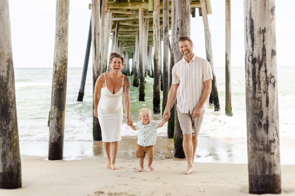 Family running toward the camera laughing in Ocean City