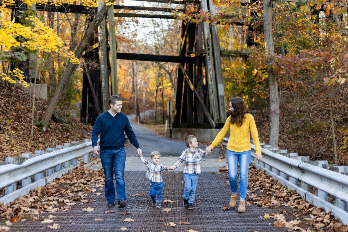 Natural family portrait with parents swinging child between them